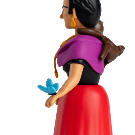 A stylized figurine with a colorful design featuring a woman in a purple shawl and red dress, a monkey on her shoulder, and a blue butterfly on her hand.