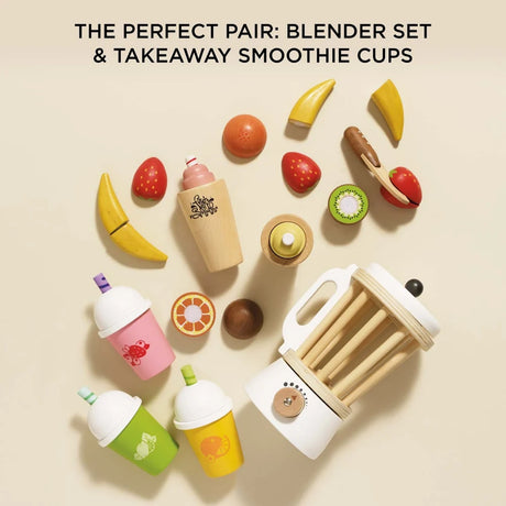 Wooden toy blender set with takeaway smoothie cups, velcro fruits, and a toy knife on a neutral background.