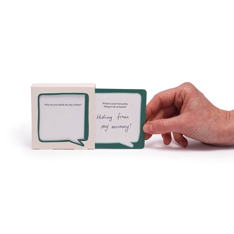 A hand pulling a prompt card with handwritten text out of a speech bubble display box.