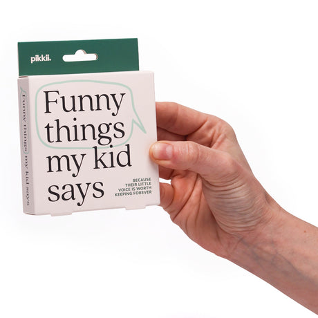 Hand holding a Pikkii box titled "Funny things my kid says" against a white background.