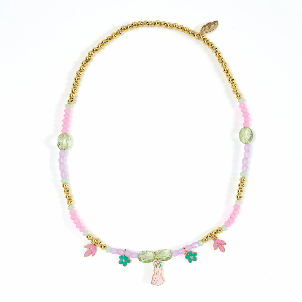 A colorful necklace featuring gold beads, pastel pink and lavender accents, and charms shaped like a bunny and flowers. The design is playful and whimsical.
