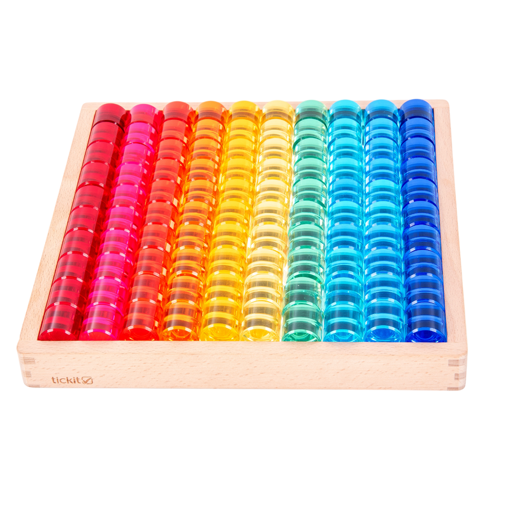 A wooden tray with a mirrored base and colorful gem-like insets, designed for sensory play, loose parts exploration, and visual stimulation.