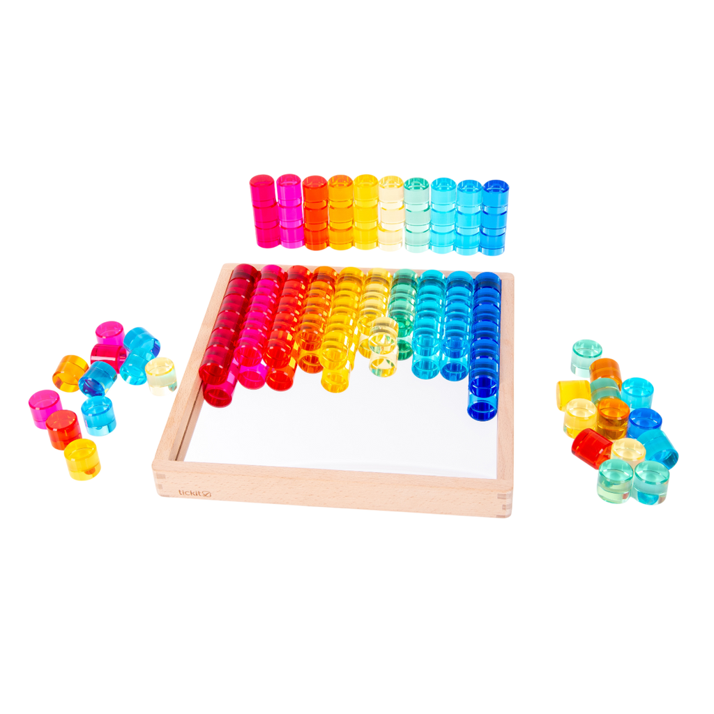 A wooden tray with a mirrored base and colorful gem-like insets, designed for sensory play, loose parts exploration, and visual stimulation.