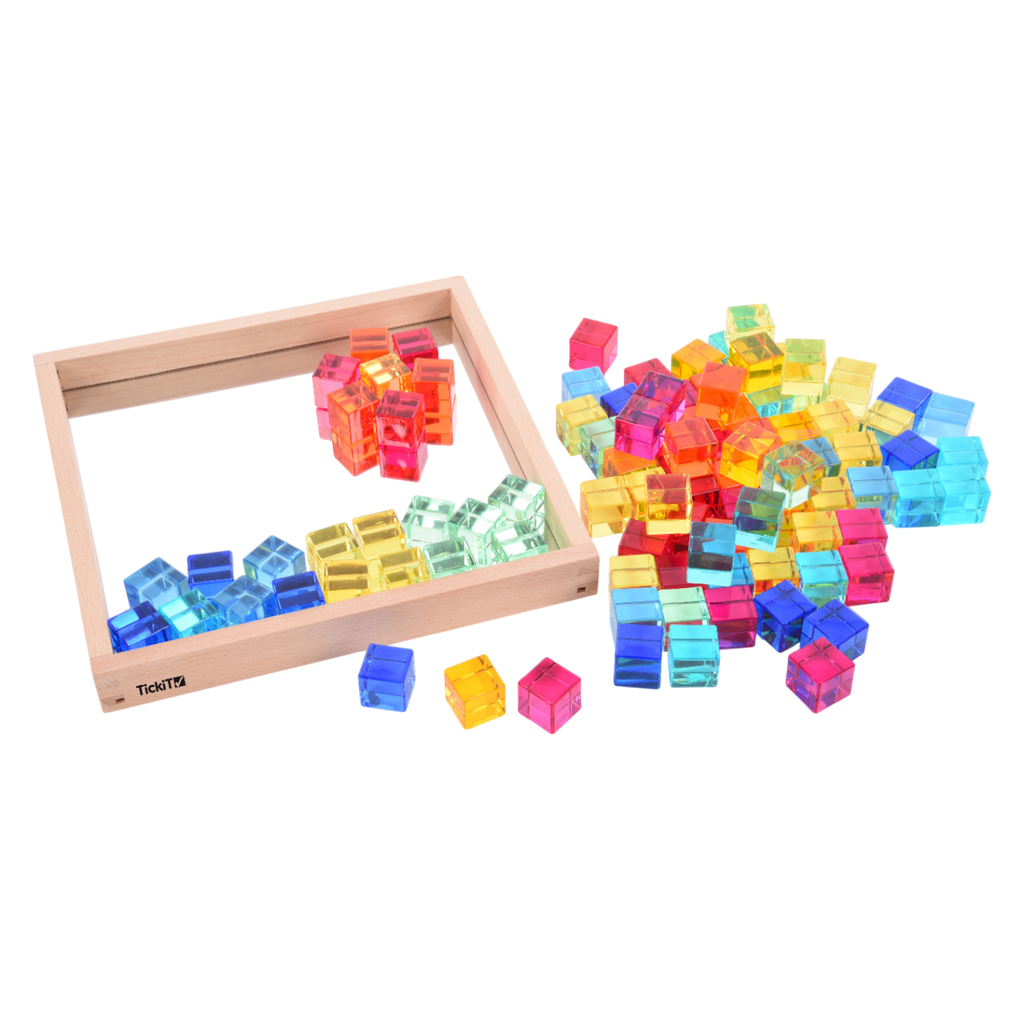 A square wooden tray with a mirrored base and colorful gem-like insets, designed to inspire sensory exploration, pattern making, and visual play.