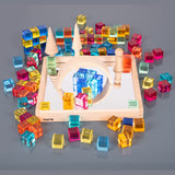 A square wooden tray with a mirrored base and colorful gem-like insets, designed to inspire sensory exploration, pattern making, and visual play.