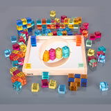 A square wooden tray with a mirrored base and colorful gem-like insets, designed to inspire sensory exploration, pattern making, and visual play.
