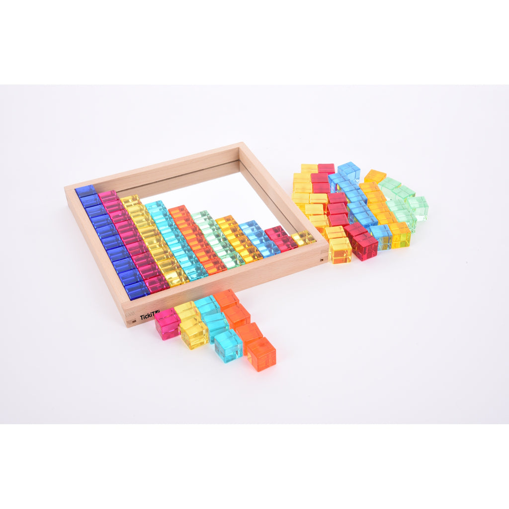A square wooden tray with a mirrored base and colorful gem-like insets, designed to inspire sensory exploration, pattern making, and visual play.