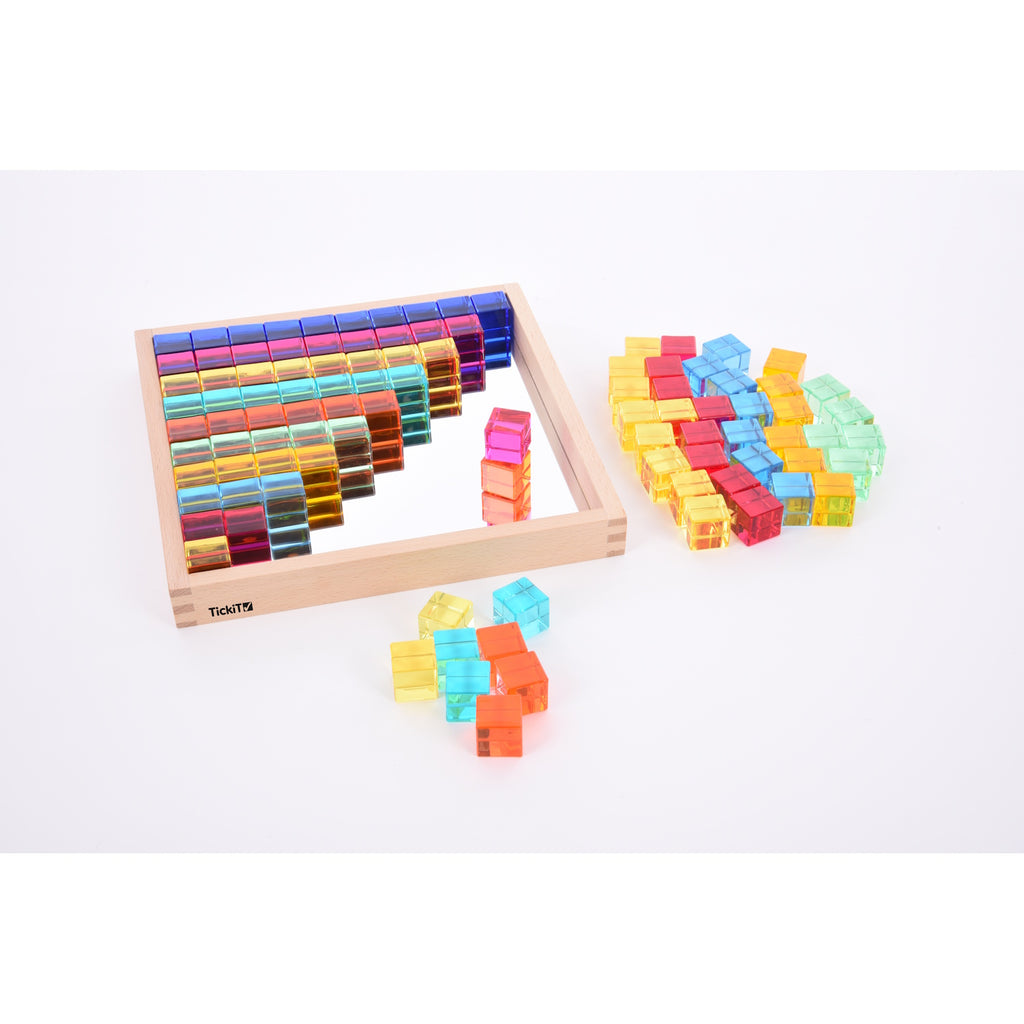 A square wooden tray with a mirrored base and colorful gem-like insets, designed to inspire sensory exploration, pattern making, and visual play.