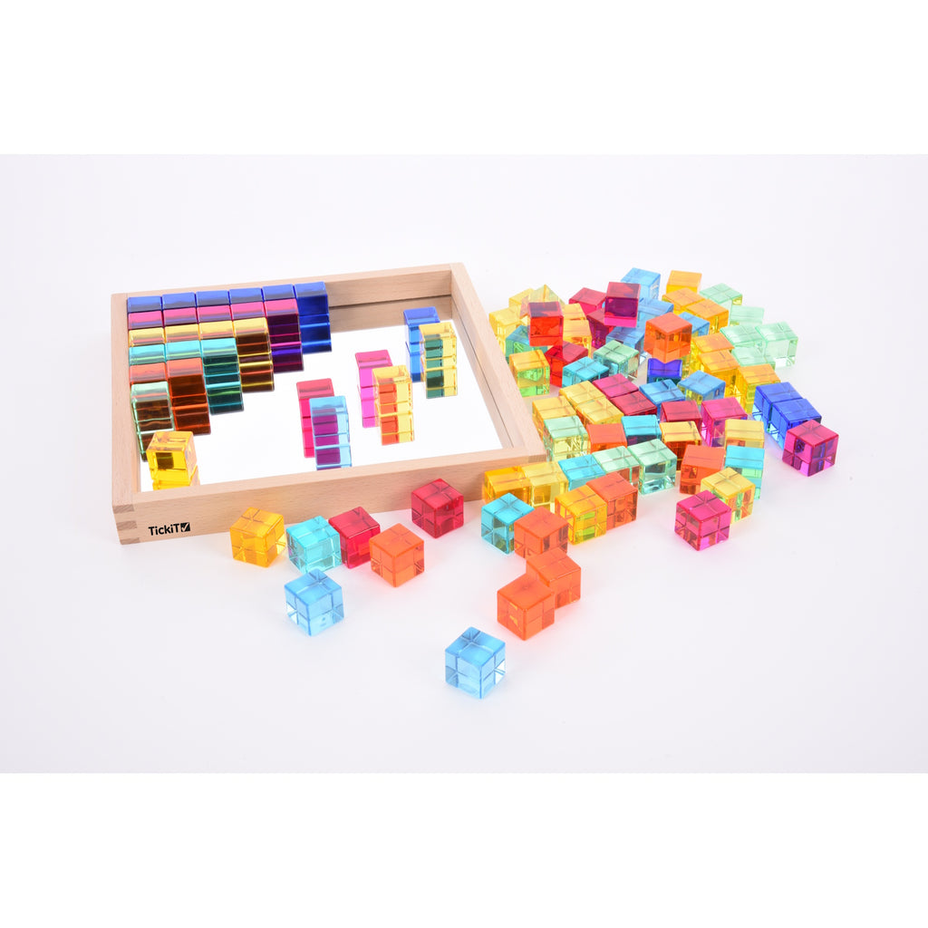 A square wooden tray with a mirrored base and colorful gem-like insets, designed to inspire sensory exploration, pattern making, and visual play.