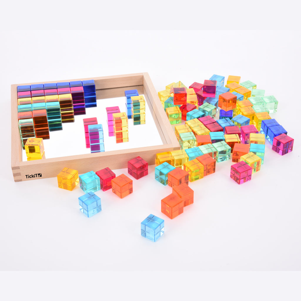 A square wooden tray with a mirrored base and colorful gem-like insets, designed to inspire sensory exploration, pattern making, and visual play.