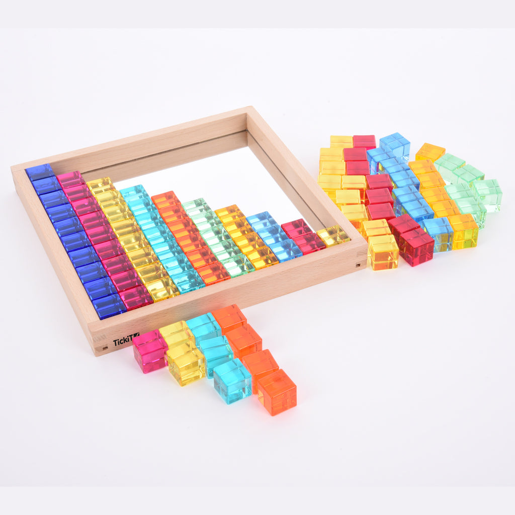 A square wooden tray with a mirrored base and colorful gem-like insets, designed to inspire sensory exploration, pattern making, and visual play.