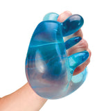 A hand squeezes a glossy, translucent blue stress ball with a marbled effect. The image conveys a sense of relaxation and tactile satisfaction.