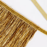 Close-up of metallic gold tinsel fringe with a glittery trim along the top border.