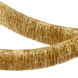 Side view of a double-layered metallic gold tinsel fringe garland swagged across a white background.