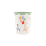Paper cup with a green scalloped border, illustrated with a dog, a rabbit holding balloons, and bunting.