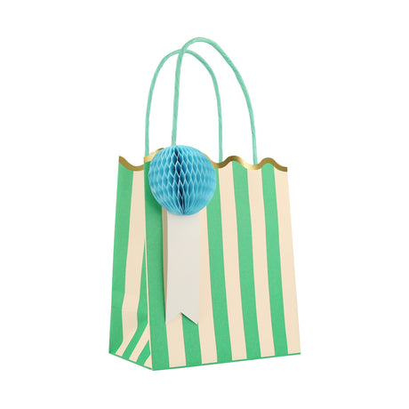 Green and cream striped party bag with gold scalloped edge, teal handles, and a light blue honeycomb pom-pom.