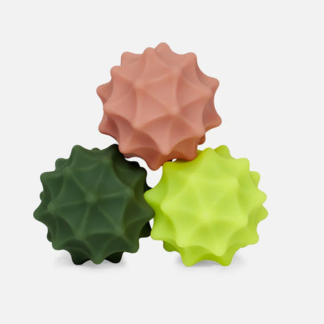 Three spiky silicone magnetic fidget spheres stacked in pink, dark green, and bright yellow.