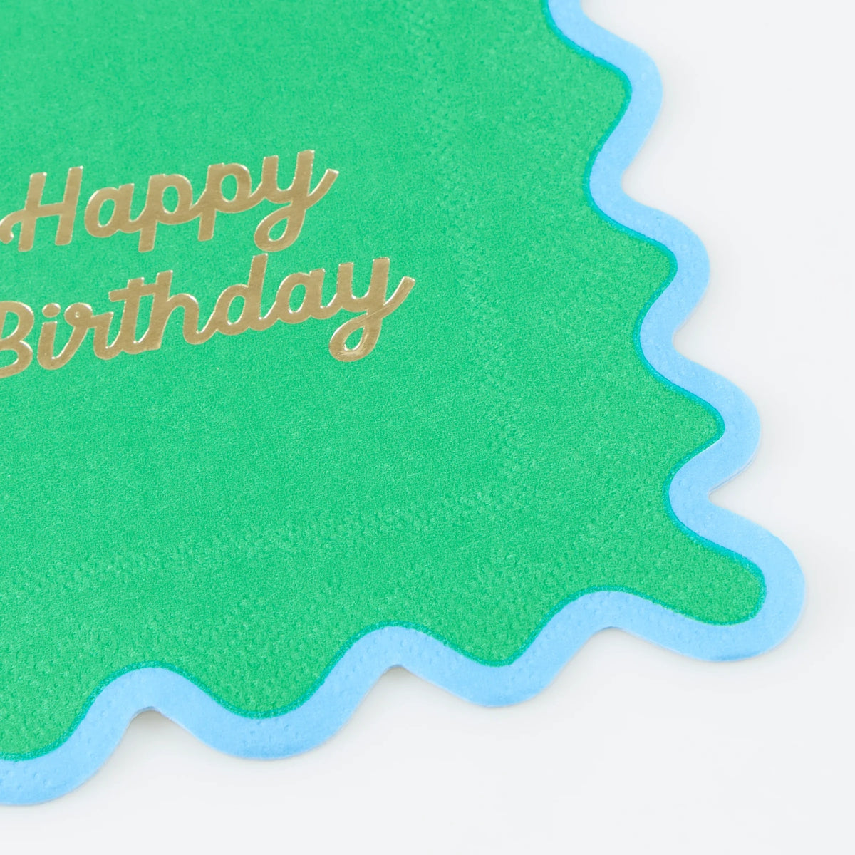 A green wavy napkin with a light blue border and "Happy Birthday" written in gold script.