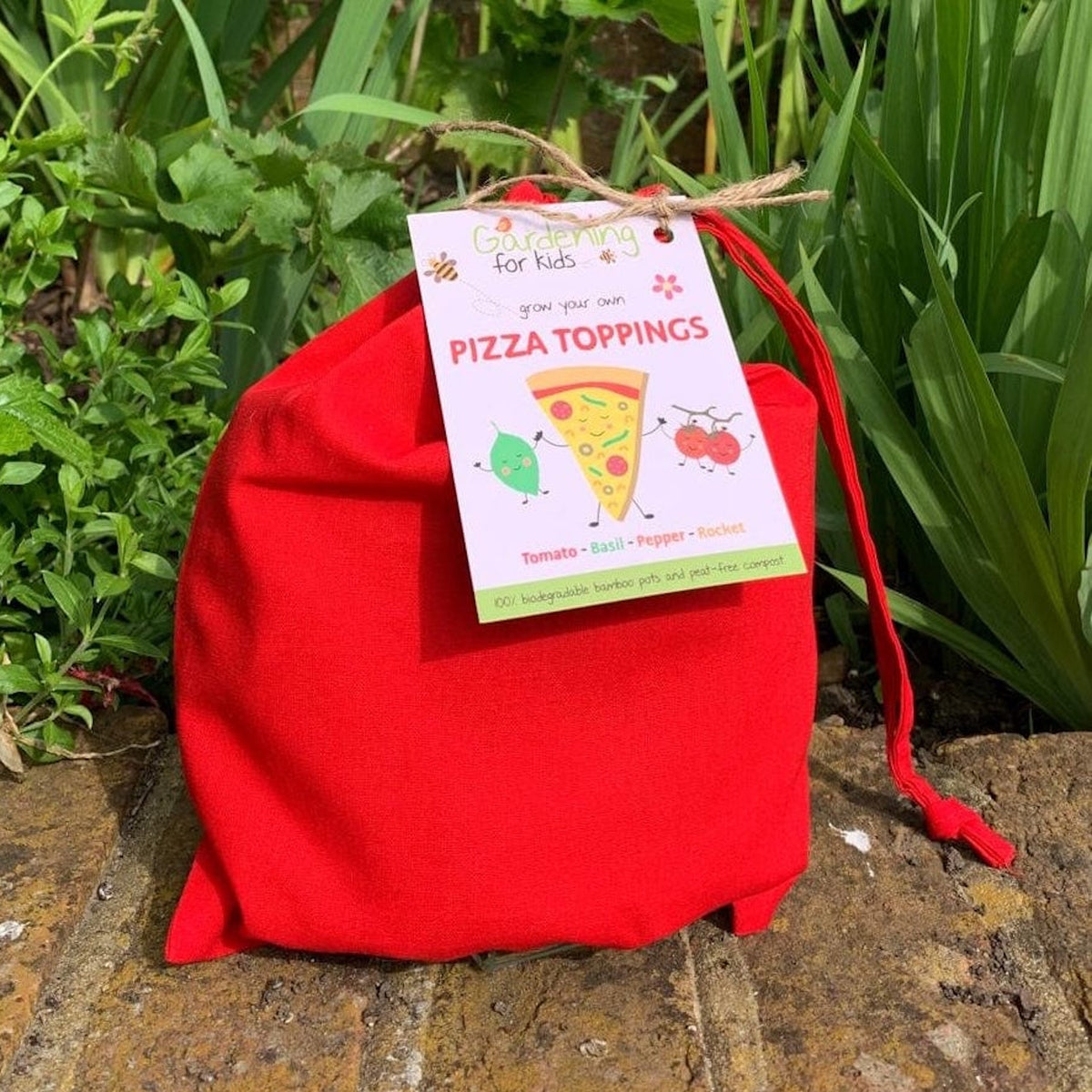 Red fabric gift bag with a tag reading "Gardening for kids: grow your own PIZZA TOPPINGS."