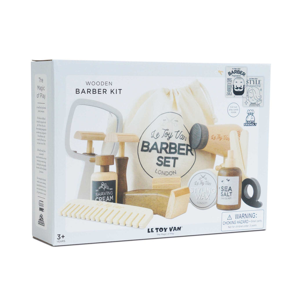 Toy barber kit packaging featuring wooden grooming tools, including a mirror, comb, shaving cream, and brush, branded "Le Toy Van." Fun, playful design for ages 3+.