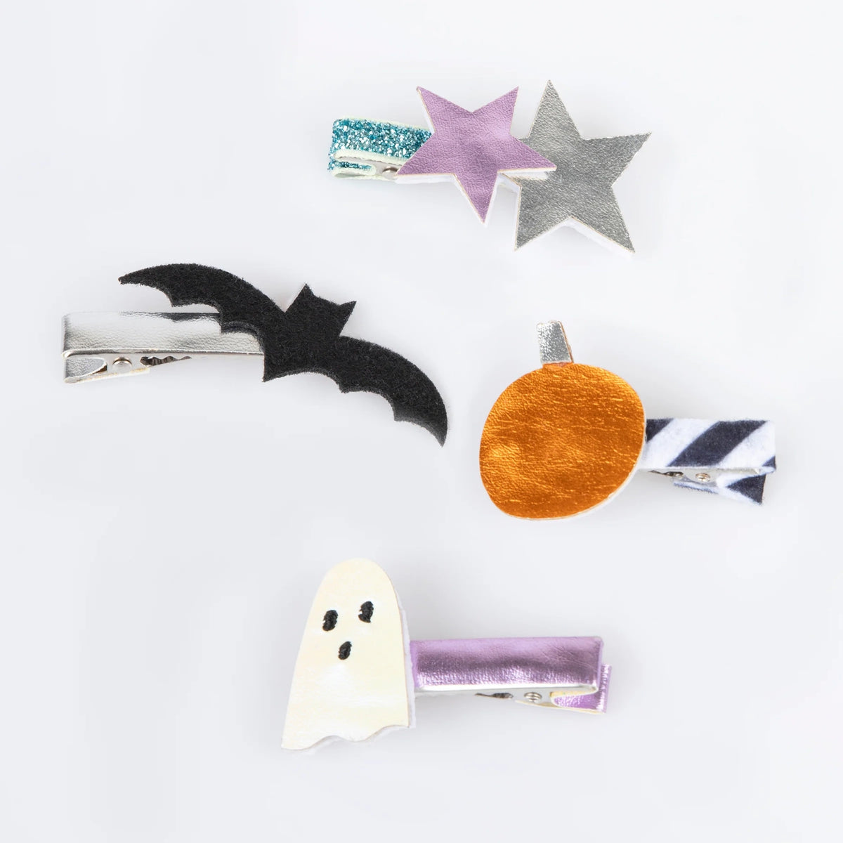 Four Halloween hair clips featuring a white ghost, black bat, orange pumpkin, and metallic stars.