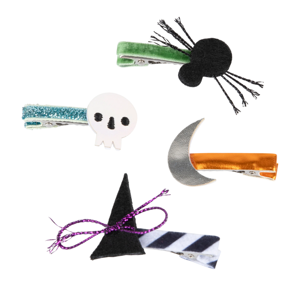 Four Halloween-themed hair clips on a white background: a green spider, silver skull, orange with silver moon, and black witch hat with purple ribbon. Fun and spooky.