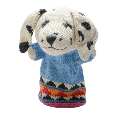 A knitted dog puppet with floppy, spotted ears wears a light blue sweater. The hem features colorful zigzag patterns, set against a white background.