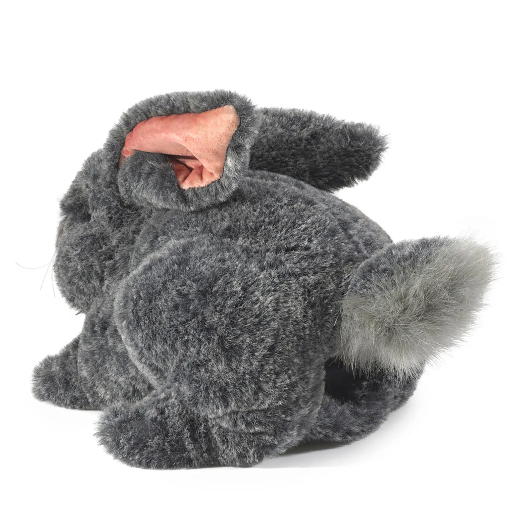 A fluffy owl with thick gray fur and a pinkish facial disc, resting with its eyes closed. The soft texture and calm pose convey a sense of tranquility.