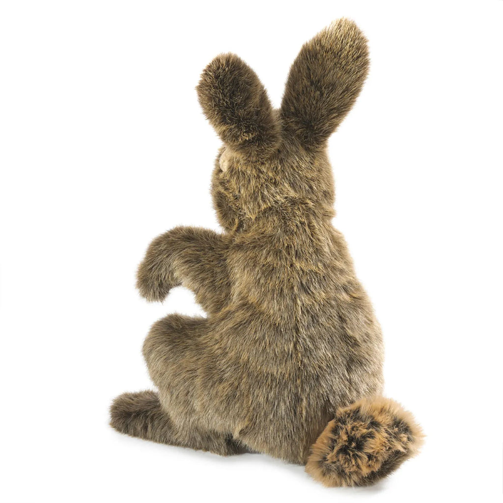 A plush, brown rabbit toy sits on a white background, showcasing its fluffy tail and upright ears. The soft texture suggests cuddliness and warmth.