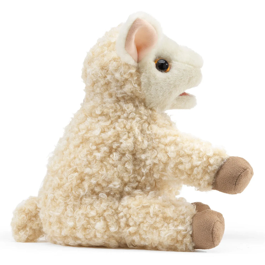 A plush lamb toy with curly cream fur sits with brown hooves and floppy ears, its soft face conveying a gentle and playful expression.