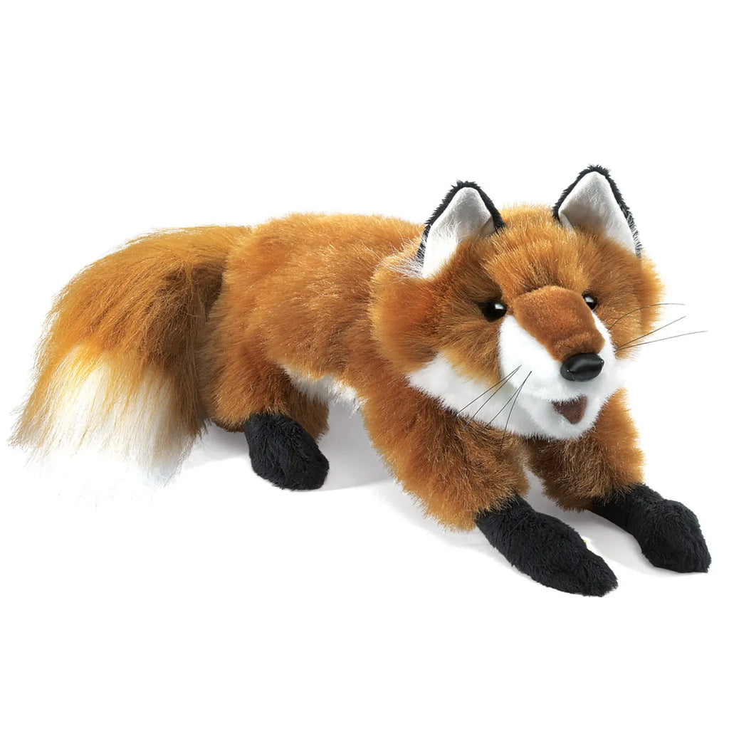 A plush fox toy with realistic features, including soft brown fur, black limbs, and a fluffy tail. It has an alert, playful expression.