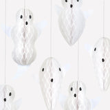 Close-up of white paper honeycomb hanging ghost decorations showcasing their textured detail and facial expressions.