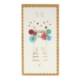 Packaged Meri Meri "Happy Birthday" cake topper with colorful honeycomb embellishments on a scalloped card.