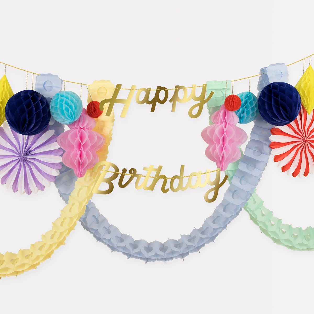 Close-up of a Happy Birthday garland with gold script letters surrounded by tissue fans and honeycomb shapes.