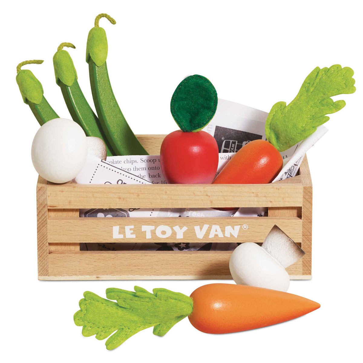 Wooden toy vegetable set in a Le Toy Van crate with a carrot and mushroom sitting in front.