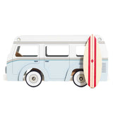 Vintage-style light blue and white wooden toy camper van with a red-striped surfboard leaned against it.