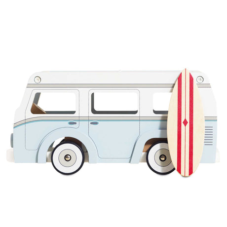 Vintage-style light blue and white wooden toy camper van with a red-striped surfboard leaned against it.