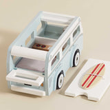 Wooden toy vintage camper van in light blue and white with a surfboard on its removable roof.
