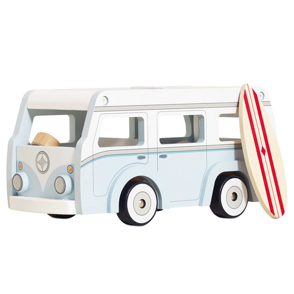 Toy vintage van in light blue with white details, featuring a detachable roof. A stylish surfboard with red stripes leans against the van, evoking a fun, coastal vibe.