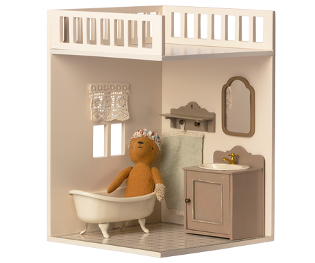 A minimalist dollhouse bathroom with two small windows and curtains, featuring a decorated tiled floor.