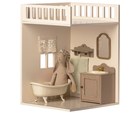 A minimalist dollhouse bathroom with two small windows and curtains, featuring a decorated tiled floor.
