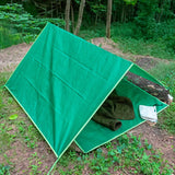 Huckleberry Hideaway green A-frame kids outdoor camping tent shelter set up in a woodland forest.