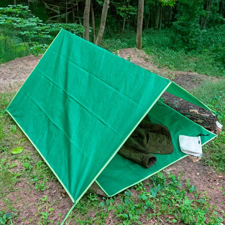 Huckleberry Hideaway green A-frame kids outdoor camping tent shelter set up in a woodland forest.