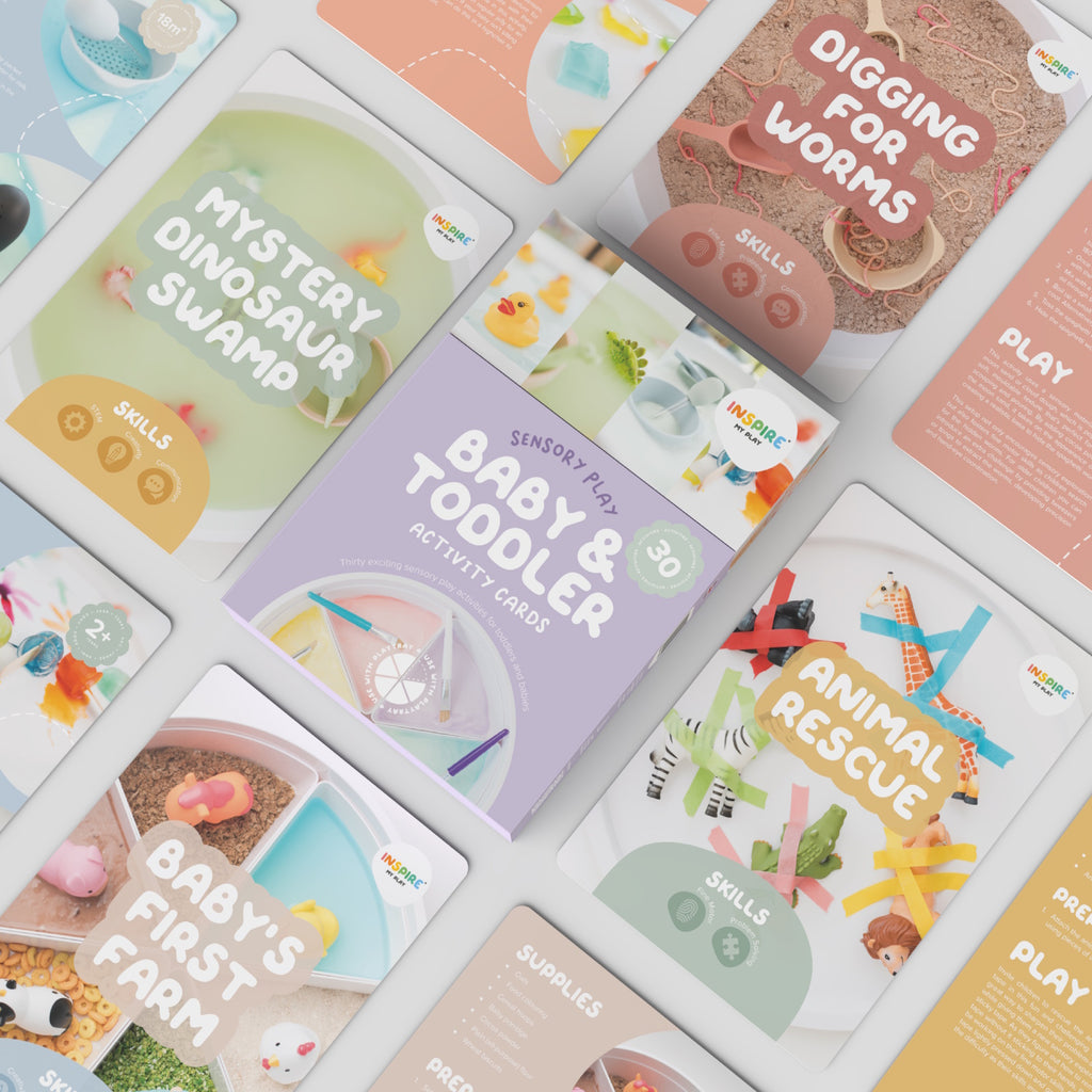 Box of "Baby & Toddler Activity Cards" for sensory play. Features playful design, pastel colors, rubber duck, paint, and crafting materials.