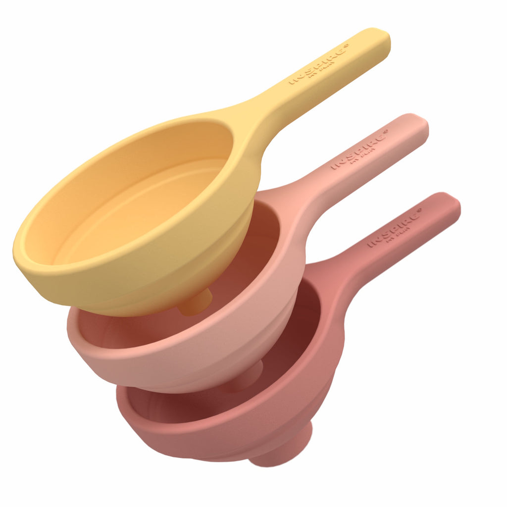 Three nested silicone funnels in pastel colors coral and yellow, stacked vertically. They convey a neat, organized kitchen accessory setup.