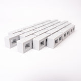 A close-up of rows of small, rectangular, gray blocks with square openings, aligned diagonally on a white background, creating a minimalistic pattern.