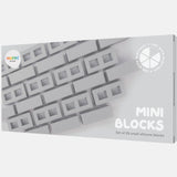 Packaging of 'Mini Blocks' showing gray silicone blocks arranged in a pattern. The text reads 'Set of 25 small silicone blocks.' Modern, minimalist design.