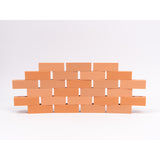 Silicone mini bricks, each brick is terracotta-colored with round holes, conveying a playful tone.