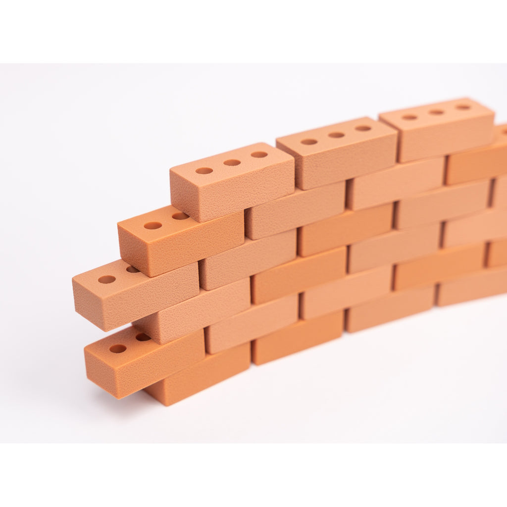 Silicone mini bricks, each brick is terracotta-colored with round holes, conveying a playful tone.