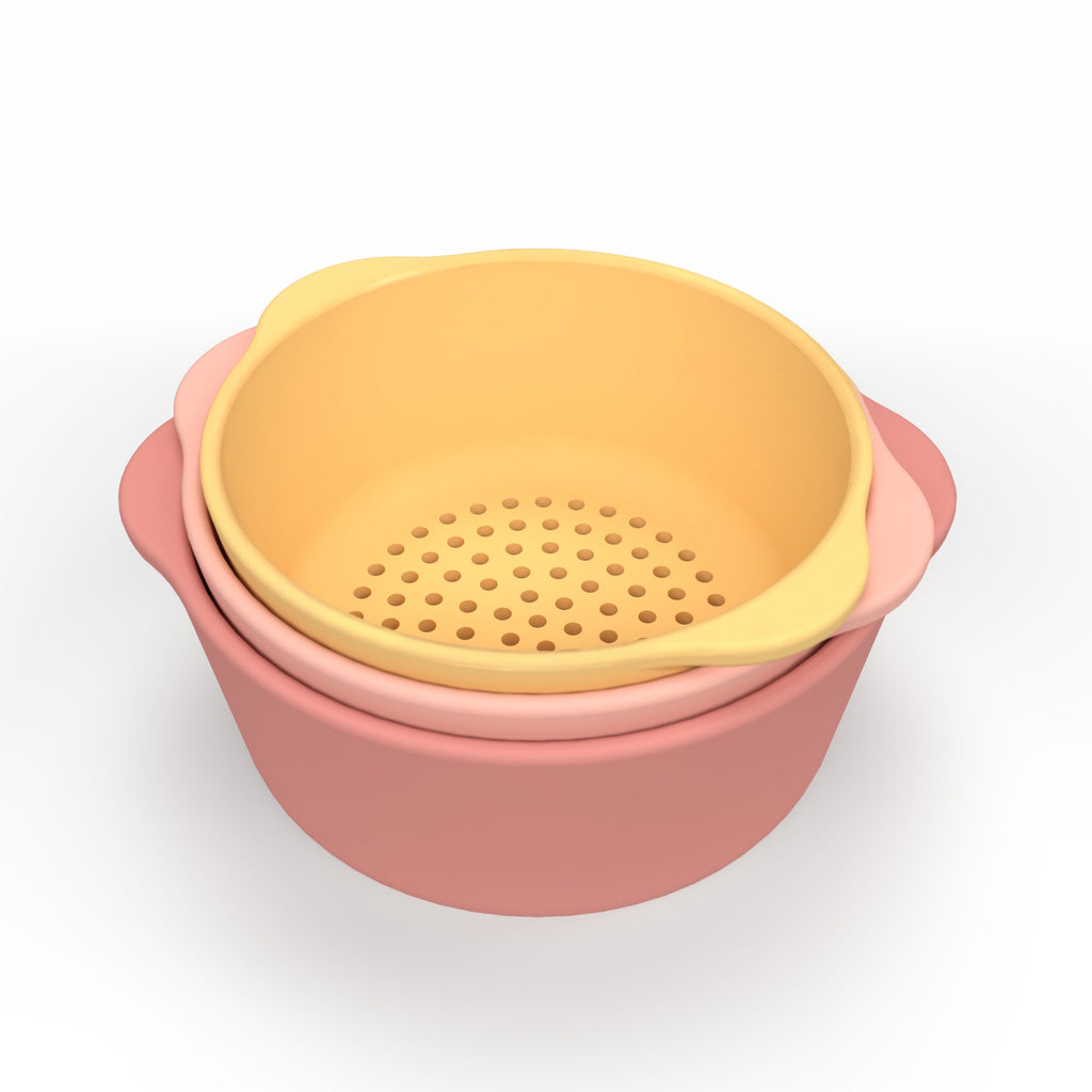 Three pastel silicone bowls; one yellow with holes as a colander, two solid pink, nested together. Minimalist design on a white background.